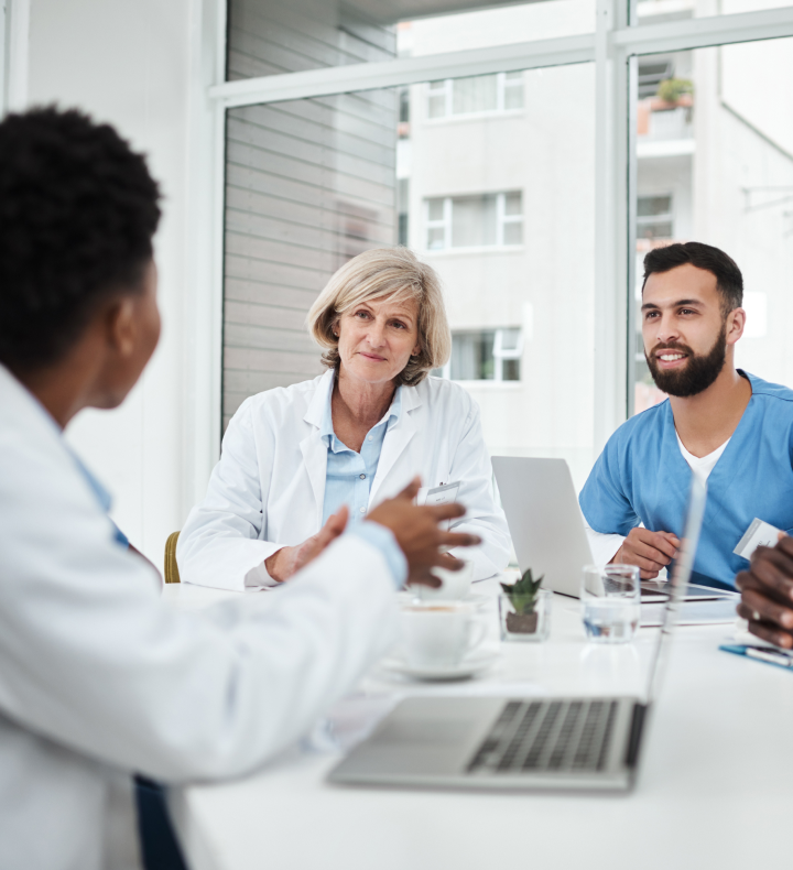 Clinicians and practice staff meet around a conference table