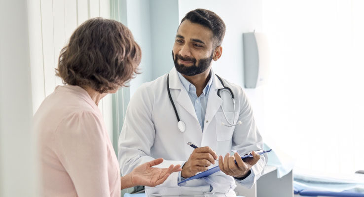 Doctor with a friendly smile speaking to a patient