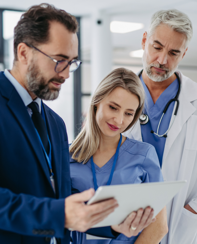 Two physicians and a practice administrator review a tablet together